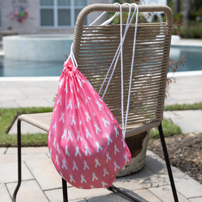 NAVIGATOR<sup>&reg;</sup> Pink Ribbon Drawstring Backpack—This handy lightweight tote has a cinch top closure and can be worn as a backpack. Measures 17.5&quot; x 14.5&quot;  and opens to 13.5&quot; wide.